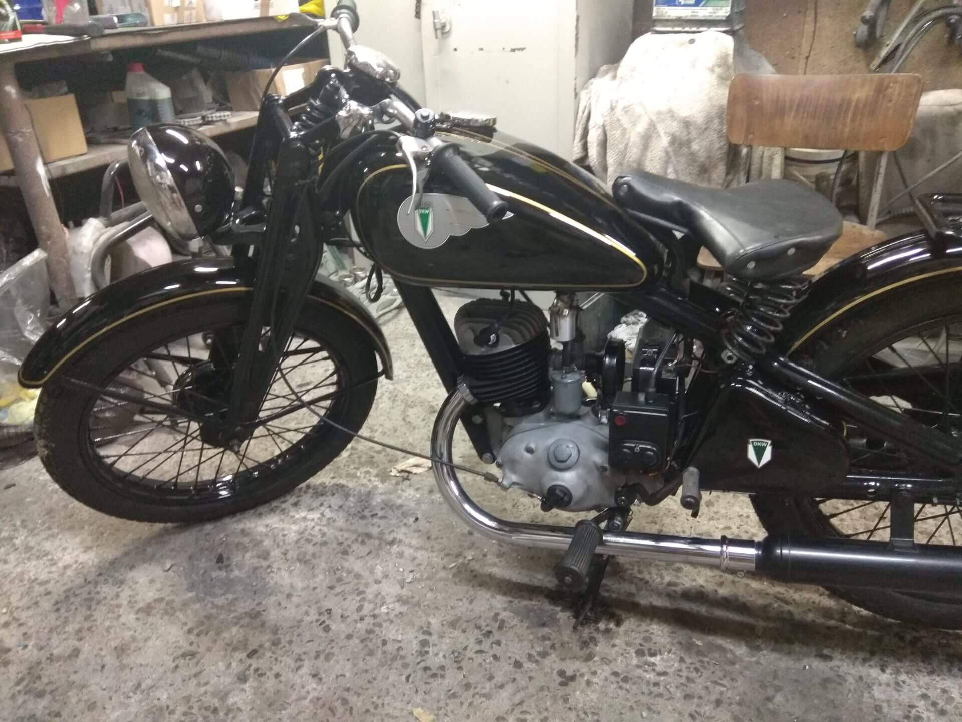 Odrestaurowany przedwojenny motocykl z czarnym, ręcznie malowanym zbiornikiem w warsztacie STH Garaż.